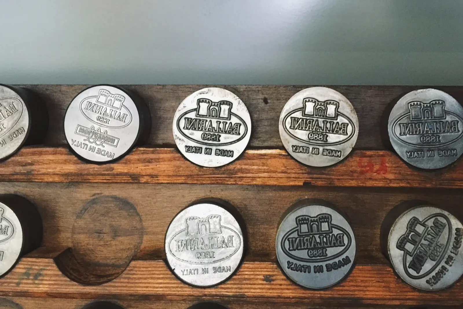Rows of vintage Ballarini metal stamps showing the castle gate and Made in Italy lettering